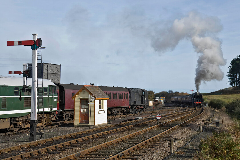 D5631, stabeld & 92203, 10.30 Sheringham-Holt, Weybourne station 
 The run into Weybourne station from the east is a little tricky for drivers. Up until a short distance from the station, the line is climbing steadily so the locomotives have to still be under power until just beyond where I have placed the train in this photograph. It shows 9F 92203 'Black Prince' leading the 10.30 Sheringham to Holt service. To the left in the depot yard D5631 and a former Class 11 shunter number 12131. 
 Keywords: D5631 92203 10.30 Sheringham-Holt Weybourne station 9F Black Prince