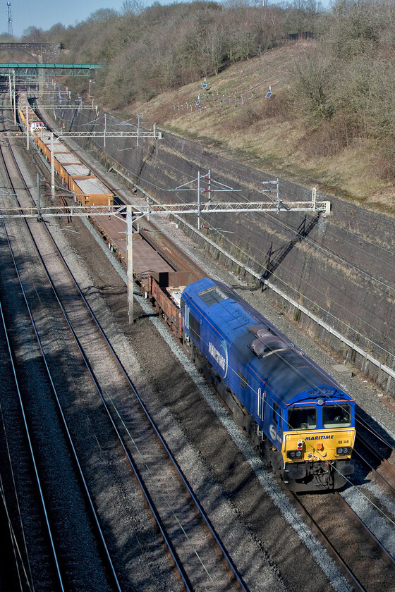 66148, 11.22 King's Langley-Crewe Basford Hall (7R02, 5L), Roade cutting 
 Adding a splash of bright blue to Roade cutting 66148 'Maritime Intermodal Seven' brings up the rear of the returning 7R02 11.22 King's Langley to Crewe Basford Hall engineering train. The variety of wagons in the view from this reverse angle of the train gives an idea of their diverse nature. 66050 'EWS Energy' was leading the train at the front. Both these locomotives are not particularly common in my photographic archive so it made a change to capture them. 
 Keywords: 66148 11.22 King's Langley-Crewe Basford Hall 7R02 Roade cutting Maritime Intermodal Seven