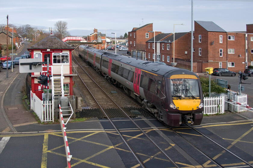 170109, XC 09.22 Birmingham New Street-Cambridge (1L34, RT), Oakham level crossing 
 170109 working the 09.22 Birmingham to Cambridge Crosscountry service leaves Oakham station crossing the busy level crossing that blights motorists and other road users in the town. Able-bodied pedestrians fare better as they can use the footbridge that I am standing on to take this photograph. Notice the well-kept and recently repainted 1899 Midland signal box that operates a number of semaphores in the area under absolute block and, of course, the crossing gates. 
 Keywords: 170109 09.22 Birmingham New Street-Cambridge 1L34 Oakham level crossing Crosscountry