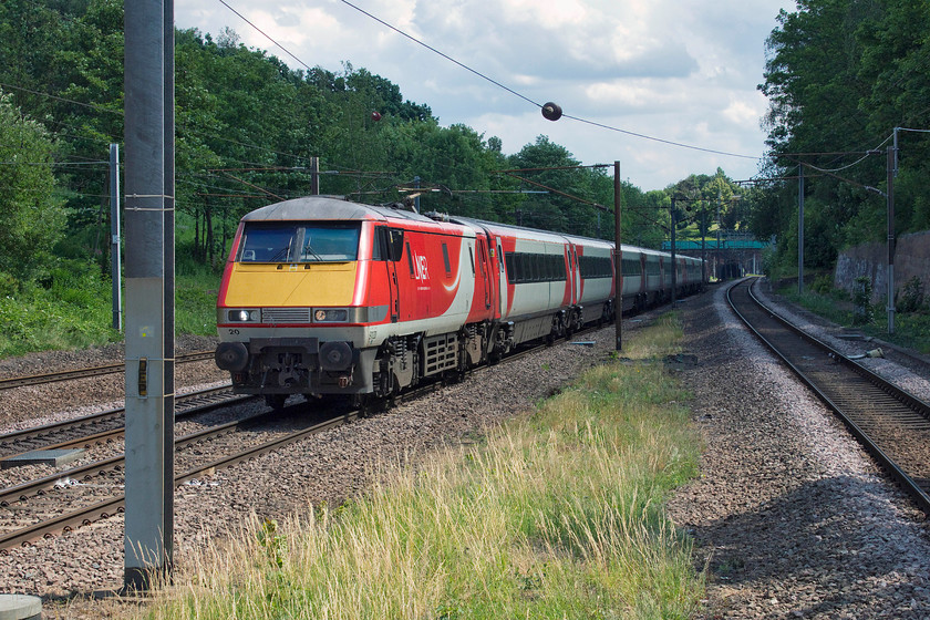 91120, GR 14.30 London King`s Cross-Newcastle (1N21, 7L), Oakleigh Park station 
 91120 just catches some summer sun but this does create some awkward lighting and contrast issues, as it approaches Oakleigh Park station with the 14.30 1N21 King's Cross to Newcastle. The twenty-nine chain long Barnet Tunnel can be seen in the background, one of a number of this section of track. This one, along with the others started out as single bores when the railway was opened in the 1870s but within twenty years another bore was dug as the track layout went from double to quadruple to cope with the massive rise in traffic, something that the Great Northern had not reckoned on....sound familiar? 
 Keywords: 91120 14.30 London King`s Cross-Newcastle 1N21 Oakleigh Park station