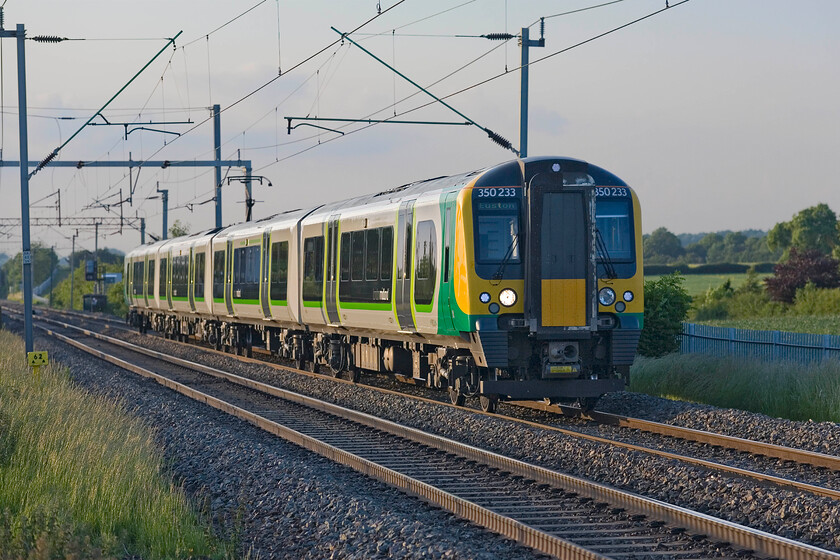 350233, LM 18.54 Birmingham New Street-London Euston (2Y22), Milton Malsor SP740553 
 London Midland's 2Y22 18.54 Birmingham New Street to Euston passes Milton Malsor worked by 350233 and another unit. With the build-up of clouds from the east, the summer evening light is changing subtly as the sun sets lower in the summer solstice sky. 
 Keywords: 350233 18.54 Birmingham New Street-London Euston 2Y22 Milton Malsor SP740553 London Midland Desiro