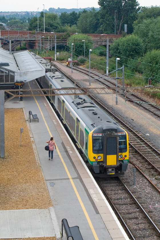 350238, LM 14.25 Northampton-Birmingham New Street, Northampton station (from temporary footbridge) 
 The 14.25 Northampton to Birmingham New Street Desiro service waits at Northampton's platform three. This alternative view is taken from the heights of the recently installed temporary footbridge that towers above the station. This footbridge will be in use whilst the station is redeveloped over the coming year or so. 
 Keywords: 350238 14.25 Northampton-Birmingham New Street Northampton station from temporary footbridge London Midland Desiro