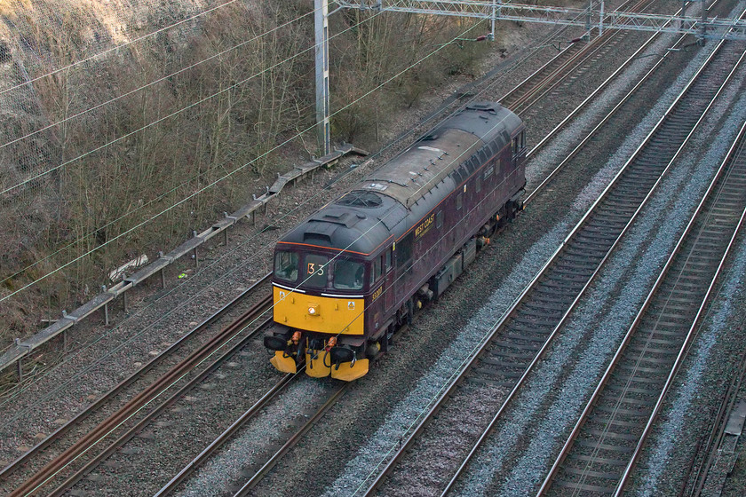 33207, 12.55 Southall-Rugby (0Z33, 8E), Roade cutting 
 This mysterious working had appeared on Realtime Trains but, as usual, I fully expected it not to operate. However, the 12.55 Southall to Rugby did depart, if a little later than planned. There was a lot of chatter on the usual forums about what it was and as it was given the 0X33 headcode most assumed it was a Crompton with people trying to work out what one it would be. As became clear, it was 33207 'Jim Martin' fitted with mini snow ploughs and it is seen here passing through Roade cutting. The locomotive had been hired in by Network Rail in anticipation of windblown debris being blown on to the line as a result of Storm Ciara that was due the following day. The idea was that if the lines did get blocked then the locomotive could 'plough' the material out of the way. There was huge disruption the following day as the storm passed through with a blanket speed restriction but I am unaware if 33207's services were called upon. 
 Keywords: 33207 12.55 Southall-Rugby 0Z33 Roade cutting Jim Martin WCR West Coast Storm Ciara