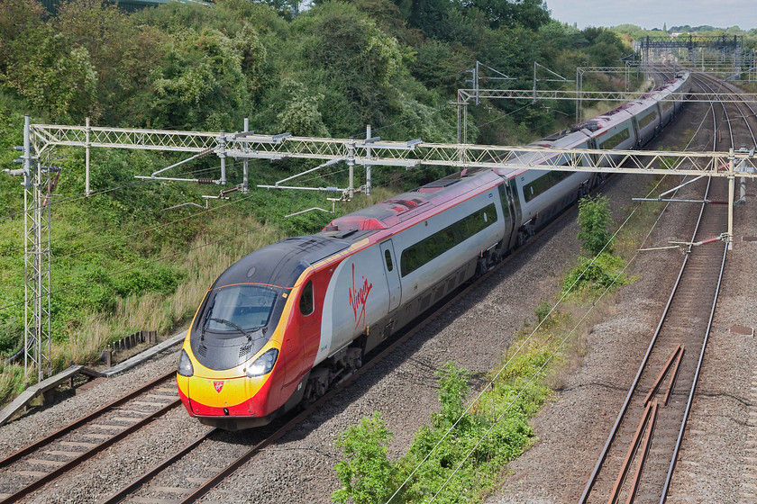 390046, VT 10.20 Manchester Piccadilly-London Euston (1A11, 6E), Victoria Bridge 
 390046 catches some morning sun on an otherwise pretty cloudy day as it passes Victoria Bridge between Rugby and Milton Keynes with the Sunday 10.20 Manchester Piccadilly to Euston. Things obviously went well on the final stage of this train's journey as it arrived six minutes early into the capital. 
 Keywords: 390046 1A11 Victoria Bridge