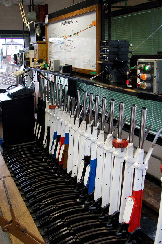 Levers, track diagram & block instruments, Newhaven Harbour signal box 
 A general view looking down the length of the 1886 Newhaven Harbour signal box. It shows the levers, block instruments and the track diagram. The signalmen, who afforded us this rare visit, was quite sanguine about its closure and was looking forward to his retirement. Notice the number of levers painted white indicating them being out of use. Andy and I were pleased to hear that the box was not being demolished but had a future as a mess-room of some kind when it become part of the Newhaven Harbour complex. I hope that it is appropriately maintained and looked after. 
 Keywords: Levers track diagram block instruments Newhaven Harbour signal box