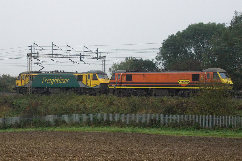 90049 & 90047, 04.57 Trafford Park-Felixstowe North (Cancelled from Ipswich) (4L97, 2E), between Roade & Ashton 
 The well-publicised move by Freightliner from electric haulage back to diesel certainly does not appear to apply to the 4L97 04.57 Trafford Park to Felixstowe. In the gloom of an early October morning, 90049 leads 90047 on the up slow line between the Northamptonshire villages of Roade and Ashton. It was an extremely tight call as to whether this Freightliner service would bowl the steam-hauled charter heading north with it well within hearing shot at this point, luckily, the freight was moving rapidly due to it being electric hauled and got out of the way. 
 Keywords: 90049 90047 04.57 Trafford Park-Felixstowe North Cancelled from Ipswich 4L97, 2E between Roade & Ashton Freightliner