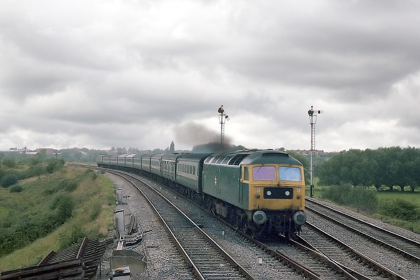 47513, 06.15 Penzance-London Paddington, Heywood Road Junction, from signal box 
 Standing at an open window of Heywood Road Junction signal box sees 47513 heading east with the 1A15 06.15 Penzance to Paddington. It has not stopped at Westbury station being seen coming off the cut-off and opening up as it does. I had arranged this visit to the signal box with the support of a signalman who lived a couple of houses from our family, Mervin Holbrook. He was based at Bradford Junction box but also did shifts at all of Westburys boxes at various times. He could be seen heading up or down our road at odd hours his Honda C90 moped with his black open face helmet as he went off and on shift. 
 Keywords: 47513 06.15 Penzance-London Paddington Heywood Road Junction from signal box