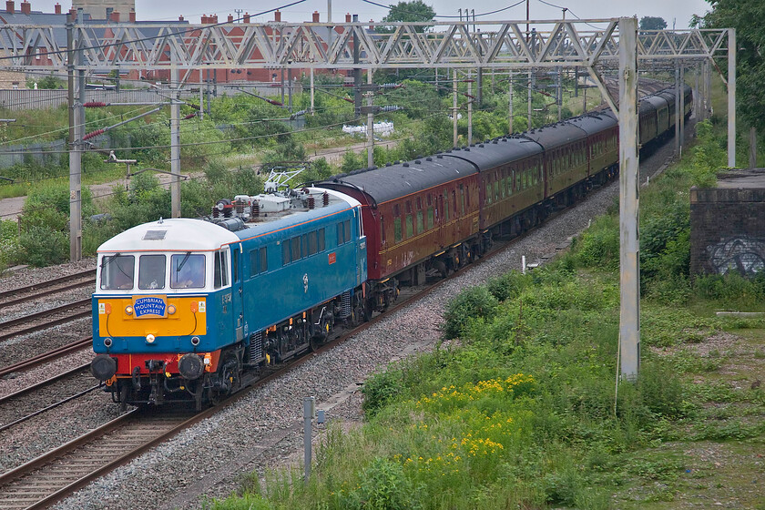 86259, the outward leg of 'The Cumbrian Mountain Express', 07.10 London Euston-Carlisle (1Z86, 26L), site of Roade station 
 On such a dull morning it was pleasing that 86259 'Les Ross/Peter Pan' was leading this train painted in a combination of such bright colours! Its Electric Blue paint scheme certainly lifts it from the dreary background and the equally dull stock making for a reasonable photograph. It is seen passing the site of Roade station leading the outward leg of the 'Cumbrian Mountain Express' that left Euston at 07.10 heading for Carnforth where 35018 'British India Line' would lead the charter on to Carlisle. 
 Keywords: 86259 'The Cumbrian Mountain Express' 07.10 London Euston-Carlisle 1Z86 site of Roade station The Railway Touring Company West Coast Railways Les Ross Peter Pan