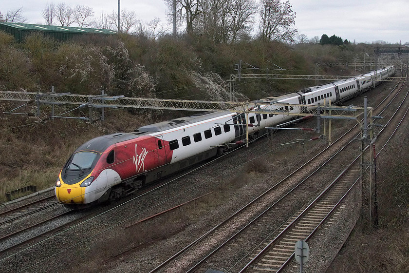 390046, VT 12.55 Manchester Piccadilly-London Euston (1A36, 1L), Victoria bridge 
 390046 heads south with the 12.55 Manchester Piccadilly to London Euston. I have said it before, but in dismal weather such as this experienced on New Year's Eve the new flying silk livery really stands out from the surroundings. 
 Keywords: 390046 12.55 Manchester Piccadilly-London Euston 1A36 Victoria bridge