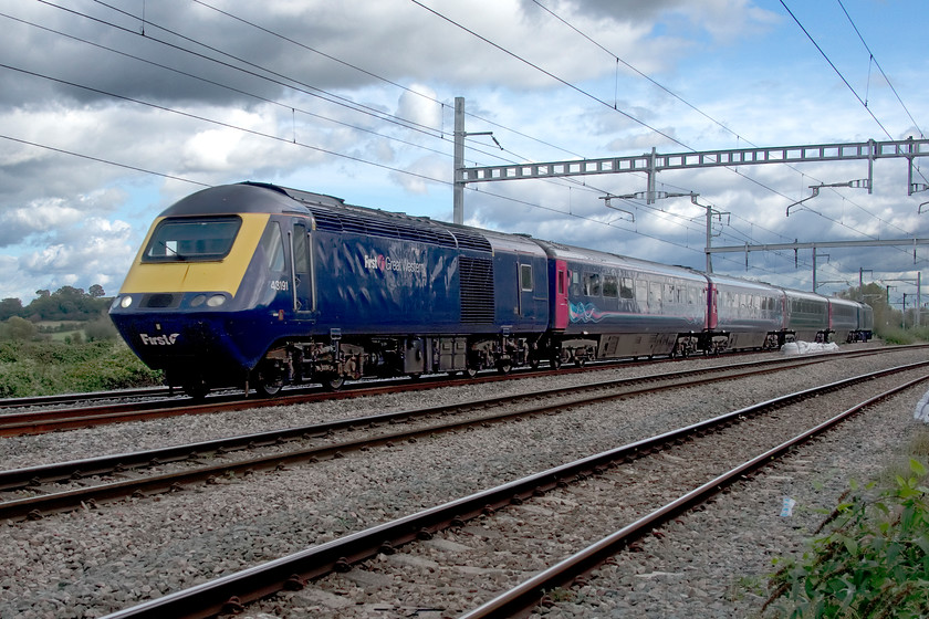 43191 & 43005, GW 11.04 Taunton-Cardiff Central (2U14, 3L), Bishton crossing 
 A four-car 'classic' HST set, as Great Westen calls it, passes Bishton level crossing between Severn Tunnel Junction and Newport powering the 11.04 Taunton to Cardiff Central service. The train is led by 43191 that was a late power car dating from May 1982 as part of 253055 with one of the earliest power cars, dating from September 1976 Western Region set 253002, at the rear. Not a fantastic picture as the sun had gone behind a cloud and the camera chose to expose for the sky rather than the foreground. I must admit to some heavy Photoshop action to get the image acceptable. 
 Keywords: 43191 43005 11.04 Taunton-Cardiff Central 2U14 Bishton crossing