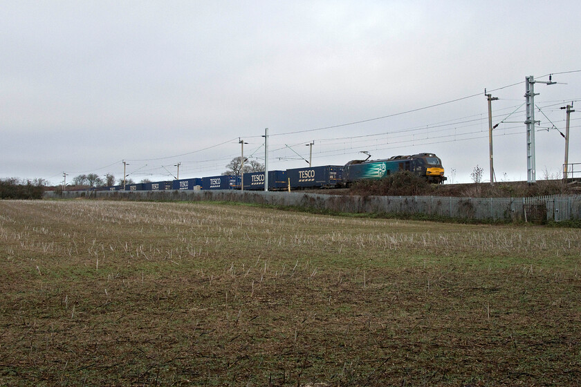 88005, 12.08 DIRFT-Tilbury (4Z48, 9L), Milton Malsor 
 On my way to Tesco in Northampton for a quick last-minute Christmas Eve present dash I paused in the village of Milton Malsor as what was one of the very few freights of this day was due to pass. I was a little rushed, hence the locomotive's unfortunate positioning being partially obscured. 88005 'Minerva' leads the 12.08 Daventry (DIRFT) to Tilbury Tesco Express. Having always carried the reporting number of 4L48 of late it has been carrying 4Z48 in line with some other changes to such numbers that appears to be linked to various industrial action taking place and consequential changes to services. 
 Keywords: 88005 12.08 DIRFT-Tilbury 4Z48 Milton Malsor Minerva