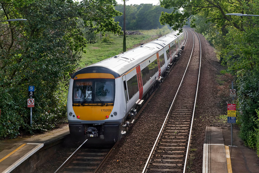 170203, LE 17.17 Great Yarmouth-Norwich (2P29, RT), Brundall Gardens station 
 Taken from the footbridge at Brundall Gradens station 170203 forms the 17.17 Great Yarmouth to Norwich 2P29 working. This shot is taken a bit into the evening sun but I like the lush spring greenery. This view would have been somewhat different a couple of years ago as a huge and dense row of coniferous trees has been removed from the area of clear meadow directly behind the train. 
 Keywords: 170203 2P29 Brundall Gardens station