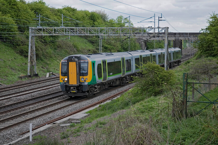 350119, LM 16.46 London Euston-Crewe, Roade 
 350119 approaches Roade on the down fast line working London Midland's 16.46 Euston to Crewe service. I am standing on the top of the truncated embankment that used to carry the former Stratford-upon-Avon and Midland Junction Railway (SMJR) over the WCML. It crossed the line on a structure known locally as the Tin bridge. 
 Keywords: 350119 16.46 London Euston-Crewe, Roade London Midland Desiro