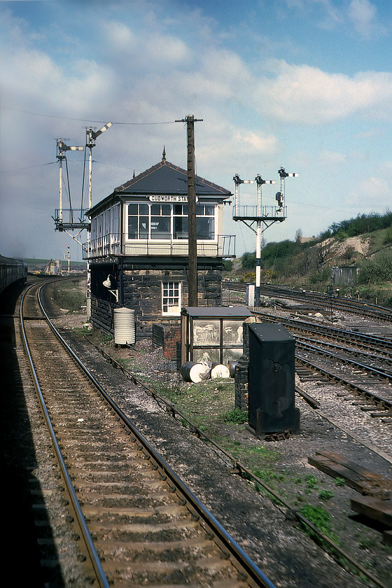 Cudworth Station signal box (Mid, 1900) 
 The first of three signal boxes within a mile or so of each other is seen from a Mk.I droplight as we pass at speed. Cudworth station signal box is a fairly grand affair that was previously known as Cudworth Station South. It was one of a handful of Midland boxes constructed with a stone base rather than of timber as was the Company's preferred method. In this view, we are on the down fast line with the up adjacent to it with the slow lines to the right. As the route was run down by BR during the 1980s the fast lines were first to be closed and removed. The much-reduced route lingered on for freight use, mainly declining coal traffic, until 1989 when complete closure came. The box was destroyed by fire in September 1988 with its two temporary replacements also being burned to the ground; arson was obviously a popular pastime in Cudworth! 
 Keywords: Cudworth Station signal box Midland Railway