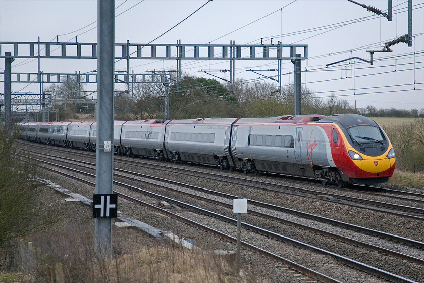 Class 390, VT 07.30 London Euston-Glasgow Central, Ashton Road bridge 
 An unidentified Class 390 Pendolino approaches Roade in the gloom of a grey February morning working the 07.30 Euston to Glasgow Central service. This is the first down Anglo-Scottish express of the day and one that any morning charters are usually timed to follow on this section of the WCML 
 Keywords: Class 390 07.30 London Euston-Glasgow Central Ashton Road bridge Virgin West Coast Pendolino