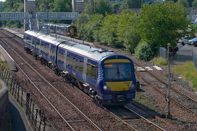 170426, SR 10.41 Glasgow Queen Street-Aberdeen (1A59) & 158730, 10.03 Edinburgh Waverley-Dunblane (2P33), Dunblane station 
 170426 gets away from Dunblane permitted by the down main semaphore DB45 controlled by the box behind where I am standing on the busy footbridge. The Class 170 is working the 1A59 10.41 Glasgow Central to Aberdeen. Sitting at the platform in the background is 158730 that has just terminated with the 10.03 from Edinburgh. Once 170426 has cleared out of section the signalmen will permit the Class 158 to draw forward, perform a crossover and then retrace its steps back into the station. Unfortunately, Dunblane is probably best remembered for the horrific events of Wednesday 13th March 1996 when Thomas Hamilton ran amok at the town's primary school killing seventeen people, mainly young school children. However, on a brighter note, it is also known for being the birth town of the tennis player Murray brothers Andy and Jamie with mum Judy still living in the town. 
 Keywords: 170426 10.41 Glasgow Queen Street-Aberdeen 1A59 158730 10.03 Edinburgh Waverley-Dunblane 2P33 Dunblane station ScotRail Super Sprinter