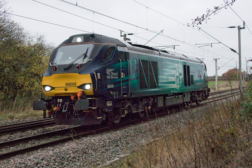 68008, 06.42 Crewe Gresty Bridge-Wembley (0A68, 20E), Watford SP614688 
 Owned by Beacon Rail and leased by DRS 68008 'Avenger' passes Watford (Northamptonshire) at a foot crossing between Long Buckby and DIRFT (Daventry). It is running as 0A68, the regular 06.42 (or thereabouts) Crewe Gresty Bridge to Wembley light engine move. Normally, this turn is composed of anything up to four or even five locomotives frequently including a Class 37. If that had been the case today it would not have fitted in this view so I can be grateful that it was just a single locomotive. 
 Keywords: 68008 06.42 Crewe Gresty Bridge-Wembley 0A68 Watford SP614688 DRS Direct rail Services Avenger