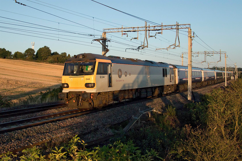 92044, CS 20.45 Inverness, 21.43 Aberdeen,19.50 Fort William-London Euston sleeper (1M16, RT), Blisworth 
 90044 'Couperin' leads the 1M16 up Caledonian Sleeper past Blisworth in Northamptonshire. It was on-time and it was interesting to see it hauled by a class 92 in its original 'as built' livery. Built by Brush in Loughborough this class 92 was released into traffic in March 1996. 
 Keywords: 92044 sleeper 1M16 Blisworth