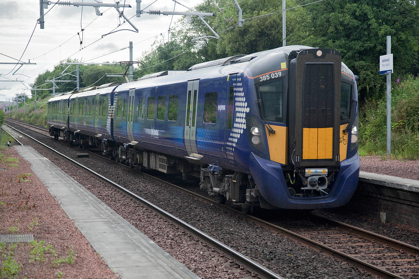 385039, SR 16.03 Glasgow Central-Edinburgh Waverley (1Y90, 4L), Addiewell station 
 385039 passes through Addiewell station forming the 16.03 Glasgow Central to Edinburgh service. Like all the stations on this route, electrification has resulted in some significant upgrading of facilities. The most noticeable, apart from the wiring, is the new footbridge with the traditional wrought iron structure removed by a crane during March 2018. It was slightly concerning to see that the accessible lifts installed at the new footbridge were out of order! 
 Keywords: 385039 16.03 Glasgow Central-Edinburgh Waverley 1Y90 Addiewell station