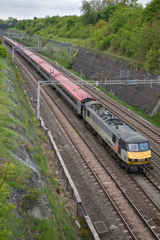 90044, LM 09.10 London Euston-Northampton (5T18), Roade cutting 
 Having deposited it first Northampton Town supporters in London to make their own way to Wembley for the League 2 playoff match with Bradford City the empty coaching stock returns to pick up more Cobblers fans. Always quick to criticise the railways, London Midland have pulled off a blinder here and should be applauded. They have hired in the Pretendolino stock and locomotive, in this case a rather tatty looking Freightliner liveried 90044, to run four footexes (two each way morning and evening) enabling fans to reach Wembley and get home again. The ECS, running as 5T18, is seen passing through Roade cutting having left Euston promptly at 09.10. 
 Keywords: 90044 09.10 London Euston-Northampton 5T18 Roade cutting Freightliner Pretendelino London Midland