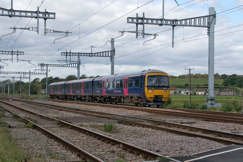 166209, GW 12.30 Cardiff Central-Portsmouth Harbour (1F17, 3L), Bishton crossing 
 Still wearing its First Great Western livery and branding from its time in the Thames valley, 166209 passes along the up fast at Bishton about to cross the infrequently used level crossing in front of the signal box. It is working the 12.30 Cardiff Central to Portsmouth Harbour. A service that back in my time living in the West Country, would have been composed of a set of Mk. I stock with a diesel upfront such as a Hymek, class 31 or a class 33. The electrification masts and wiring are fully installed here between Severn Tunnel Junction and Newport. The line of houses in the background are part of the linear village of Bishton. 
 Keywords: 166209 12.30 Cardiff Central-Portsmouth Harbour 1F17 Bishton crossing