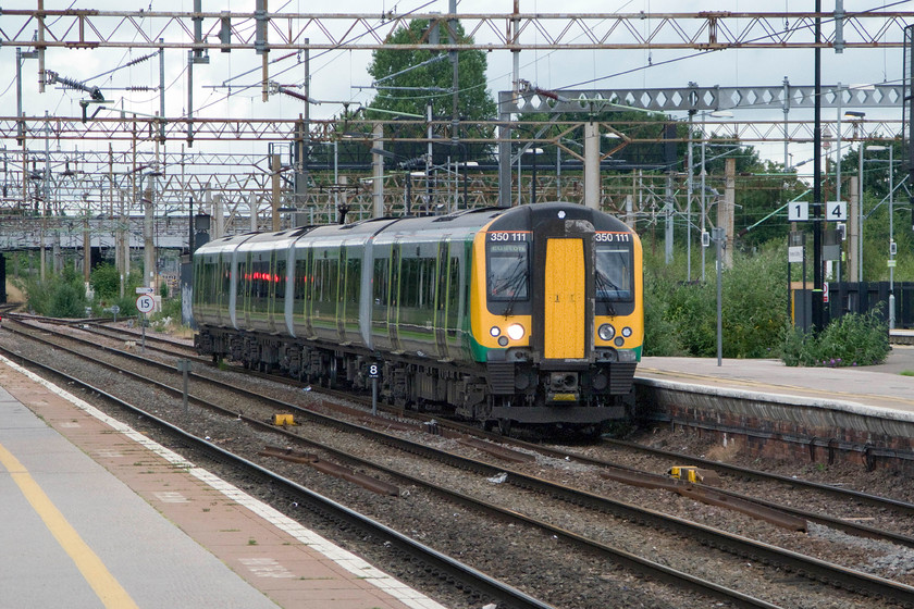 350111, LM 06.49 Crewe-London Euston (2Y00), Northampton station 
 350111 drifts into Northampton station with the 06.49 Crewe to Euton service. This view clearly shows the rampant and uncontrolled undergrowth, mainly buddleia, that appears to have taken over the platform ends and the sidings behind the train! 
 Keywords: 350111 06.49 Crewe-London Euston 2Y00 Northampton station London Midland Desiro