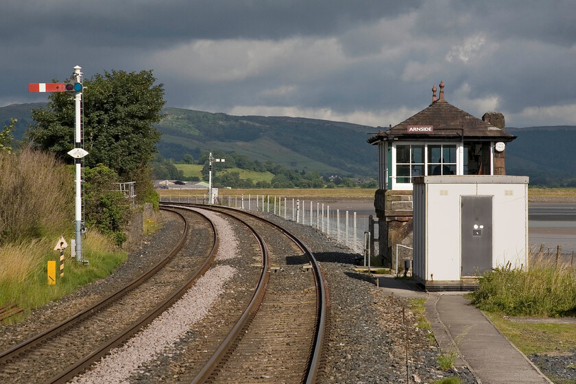 Arnside down starter & signal box (Furness, 1897) 
 The 1897 Arnside signal box is seen along with the up home and down starter signals. Just around the curve to the left the Cumbrian Cast line strikes out west crossing the estuary on Kent Viaduct that is also referred to as Arnside Viaduct. This is a structure that needs constant attention and repairs. Two years ago in 2011 it was closed for sixteen weeks whilst much work was undertaken including upgrading the rails to continuous jointed track thus enabling an increase in the line speed and causing less wear to the structure. 
 Keywords: Arnside down starter & signal box (Furness, 1897)