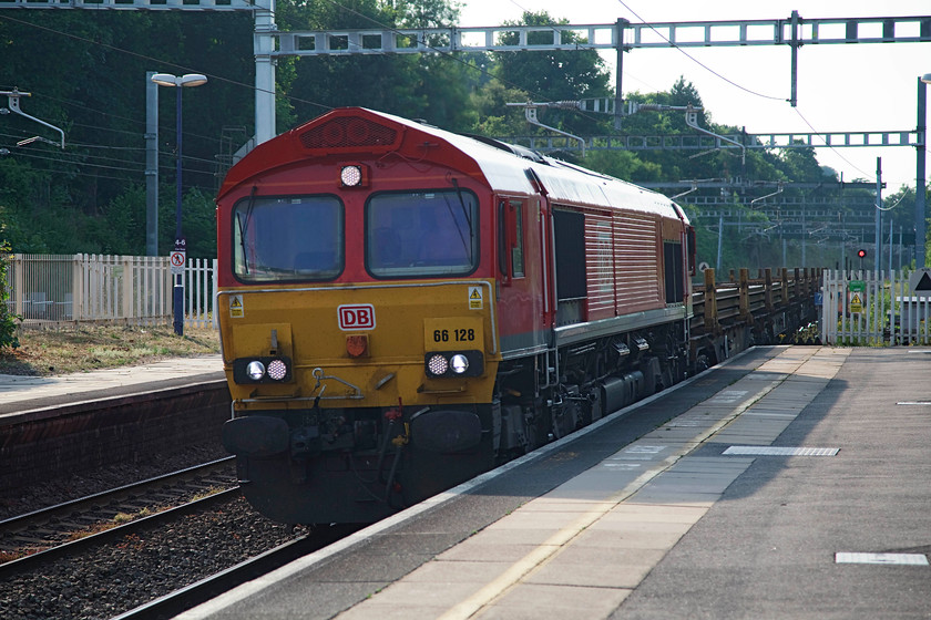 66128, 10.17 Scunthorpe TC-Eastleigh East Yard (6X01), Tilehurst station 
 In its smart new red DB branding, 66128 passes Tilehurst at speed with the 10.17 Scunthorpe to Eastleigh Yard steel flats fully loaded with lengths of new rail. It was an incredibly hot late afternoon and on this platform there was no shelter from the blaring sun. 
 Keywords: 66128 10.17 Scunthorpe TC-Eastleigh East Yard 6X01 Tilehurst station