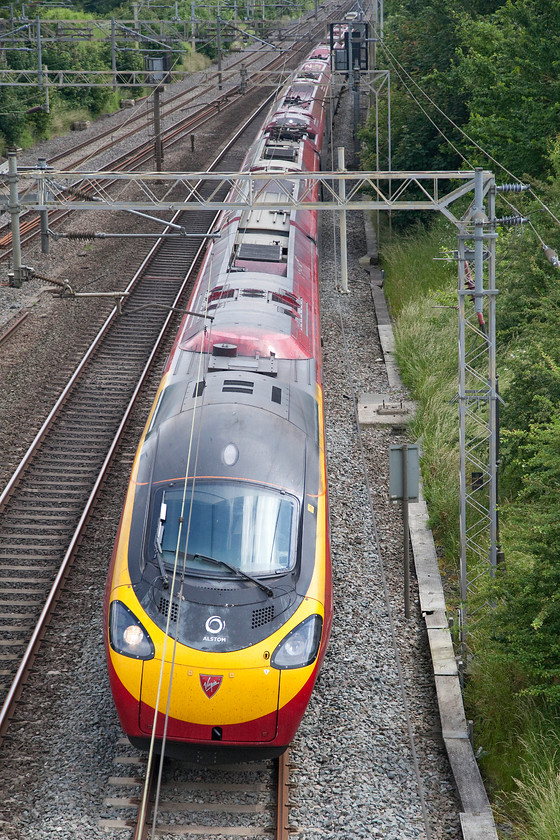 390104, VT 13.40 London Euston-Glasgow Central (9S77), Victoria bridge 
 The 9S77 13.40 Euston to Glasgow Central is about to whip under Victoria Bridge south of Roade. It is just taking the first of a number of reverse curves before entering Roade Cutting, the tilting mechanism will be primed and ready to do its stuff from here for a fair distance all the way to Rugby on the Weedon loop. 
 Keywords: 390104 13.40 London Euston-Glasgow Central 9S77 Victoria bridge