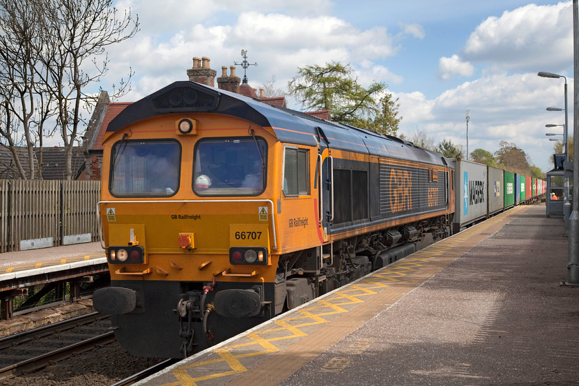 66707, 11.22 Felixstowe South-Doncaster Railport (4E33), Thurston station 
 66707 'Sir Sam Fey-Great Central Railway' shatters the peace at Thurston station as it passes leading the 11.22 Felixstowe to Doncaster Freightliner. This station is high up on an embankment with timber platforms constructed and supported from the rear down the slopes of the embankment. The 66 is named after the career railwayman Sam Fey who became the director of a number of railways, not just the Great Central, and is credited with his visionary approach to his work, for example introducing season tickets. 
 Keywords: 66707 4E33 Thurston station