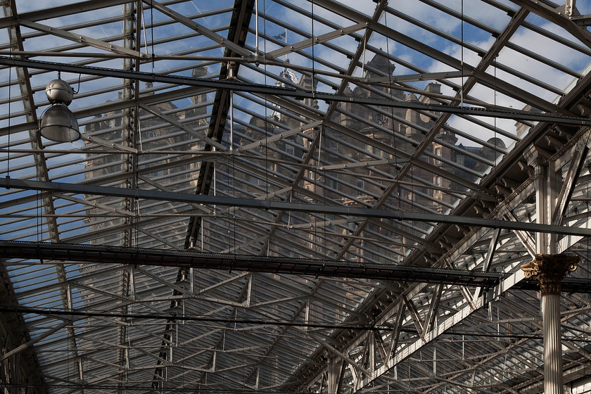 Roof & Balmoral Hotel, Edinburgh Waverley station 
 Whenever I visit one of the UK's 'grand' stations I always take the opportunity to look upwards hopefully avoiding all the other users dashing round like ants rarely taking their eyes off their devices! The roof at Edinburgh Waverley is a grand affair that lets a huge amount of natural light in flooding the concourse and platforms. Through the recently restored roof glazing, the ex North British Hotel is seen now rather ostentatiously re-named the Balmoral Hotel. 
 Keywords: Roof Balmoral Hotel Edinburgh Waverley station