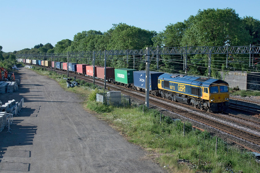 66713, 03.10 Felixstowe North-Trafford Park (4M21, 25E), site of Roade station 
 66713 'Forest City' leads the 4M21 03.10 Felixstowe North to Trafford Park through an early morning Roade. The space in the foreground was once filled with sidings that served the Simplex/Pianoforte factory that was located to the left just out of shot. This former factory site is now occupied by a vast and controversial housing estate that is just about complete at the time of writing. 
 Keywords: 66713 03.10 Felixstowe North-Trafford Park 4M21 site of Roade station GBRf GB Railfreight Forest City