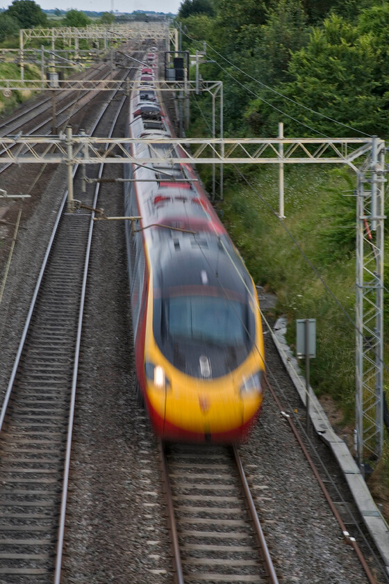 Class 390, VT 18.40 London Euston-Manchester Piccadilly (1H73), Victoria bridge 
 Not a camera or user failure but a deliberate act to emphasise the speed of the Pendolino. Utilising a slow shutter speed induces motion blur to the unidentified Class 390 as it passes Victoria bridge between Roade and Ashton working the 18.40 Euston to Manchester service. 
 Keywords: Class 390 18.40 London Euston-Manchester Piccadilly 1H73 Victoria bridge Virgin Pendolino