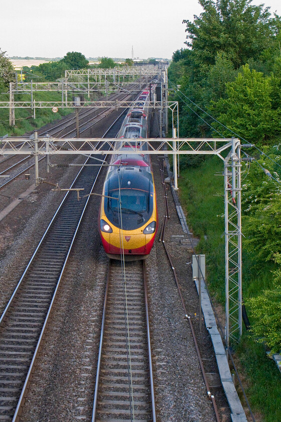 Class 390, VT 19.03 London Euston-Birmingham New Street (1G40), having been held at signal, Victoria bridge 
 A photograph that would usually require a shutter speed of anything above 1/1600 second if the subject would be kept sharp but in this example, I have selected 1/320 second. The Pendolino, working the 19.03 Euston to Birmingham New Street is still sharp as it was moving at walking pace. All trains just south of Roade had been halted a little earlier and were now on their way but very slowly, I presume due to some sort of signalling fault. 
 Keywords: Class 390 19.03 London Euston-Birmingham New Street 1G40 having been held at signal, Victoria bridge VWC Virgin Pendolino