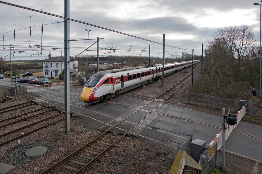 800104, GR 09.00 London King's Cross-Aberdeen (1W11, 7L), Tallington 
 Tallington level crossing on the ECML a few miles north of Peterborough is believed to be the busiest in the country where the barriers can be lowered for forty minutes out of sixty causing huge delays and congestion to users of the busy A1175. There have been discussions and plans on the table for many years to construct a bridge but as yet, nothing has materialised so the frustration of locals, road users and the various local authorities will continue. 800104 passes the level crossing working the 09.00 King's Cross to Aberdeen LNER service. 
 Keywords: 800104 09.00 London King's Cross-Aberdeen 1W11 Tallington LNER AZuma