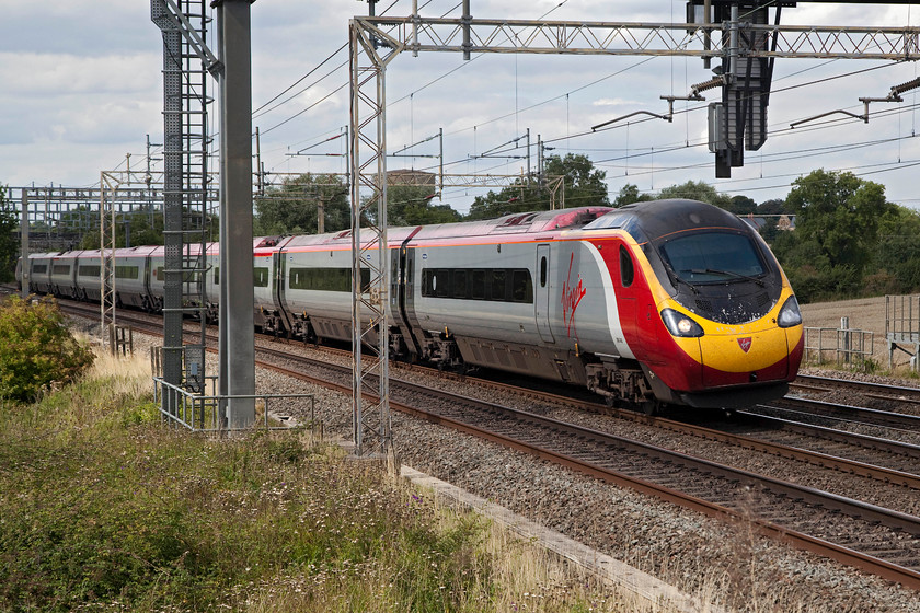 390045, VT 13.30 Birmingham New Street-London Euston (1B29, 20L), Ashton Hill 
 The 1B29 13.30 Birmingham to Euston was running a little late here just south of Roade on the southern WCML but arrived even later into London. 390045 is forming the train and is about to pass under one of Network Rail's gargantuan colour light gantrys that I can see across the fieldd from my home! 
 Keywords: 390045 1B29 Ashton Hill