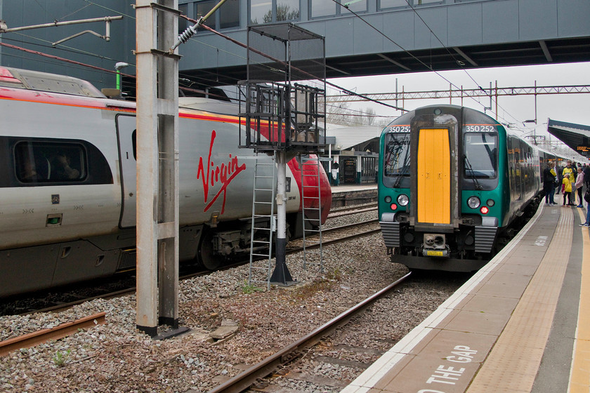 350252, LN 10.10 Northampton-London Euston (2N04, 3L) & 390148, VT 08.00 Manchester Piccadilly-London Euston (1A02, 2E), Northampton station 
 Our train south from Northampton to London Euston waits at platform one formed of 350252. This 10.10 service is one of the 'slow' stoppers that calls at virtually every station south to Euston! To the left, the rear of Virgin Trains' 390148 'Flying Scouseman' passes through the centre road forming the 1A02 08.00 Manchester to Euston service. 
 Keywords: 350252 10.10 Northampton-London Euston 2N04 390148 08.00 Manchester Piccadilly-London Euston 1A02 Northampton station