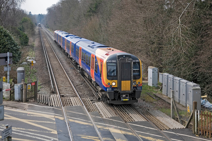 444019, SW 10.45 London Waterloo-Portsmouth & Southsea & 450080, SW 10.45 Portsmouth Harbour-London Waterloo, Milford level crossing 
 As the 10.45 Waterloo to Portsmouth and Southsea service worked by 444019 heads off into the distance 450080 heads north with the 10.45 Portsmouth Harbour to Waterloo service. The scene is captured from the public footbridge at the end of Milford station deep in the Surry countryside but still being only just over thirty miles from London. 
 Keywords: 444019 10.45 London Waterloo-Portsmouth & Southsea 450080 10.45 Portsmouth Harbour-London Waterloo, Milford level crossing South West Trains SWT