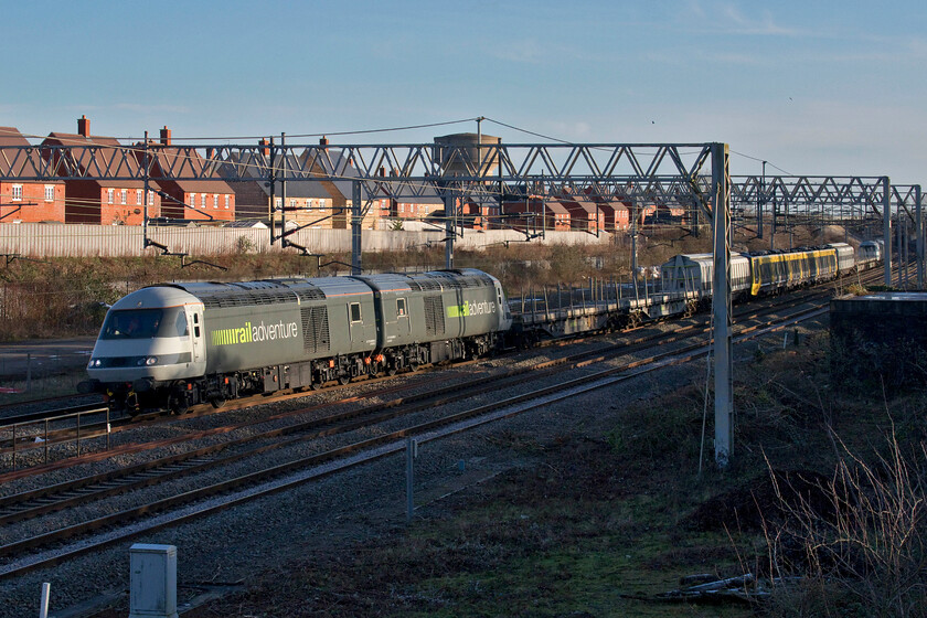 43465, 43468, 777140, 43484 & 43480, 12.32 Wembley Reception Sidings-Crewe Down Refuge Sidings (6Q43, 57L), site of Roade station 
 What a train! There had been chatter around the possible operation of this train for a while and finally today it operated in all its glory! In order to move the newly constructed Stadler Class 777 units from Wembley Yard to Crewe (for onward movement to Merseyside) the German logistics specialists' railadventure (sic) have been tasked with undertaking the work. I believe that they also brought the units from Siedlce in Poland, where they had been constructed, across Europe and through the tunnel to Dollands Moor. railadventure has modified nine redundant Class 43 HST power cars (with two more bought as donor vehicles) for use on the mainline along with translator stock. 43465 (ex Grand Central and EMT) is paired with 43468 (ex Grand Central) with 43484 (ex Grand Central & EMT) and 43480 (ex Grand Central & EMT) are seen passing Roade with 777140 sandwiched safely in the middle as the 6Q43 late running 12.32 Wembley Yard to Crewe Refuge Sidings. 
 Keywords: 43465 43468 777140, 43484 43480 12.32 Wembley Reception Sidings-Crewe Down Refuge Sidings 6Q43 site of Roade station HST Class 43 Merseyrail Railadventure