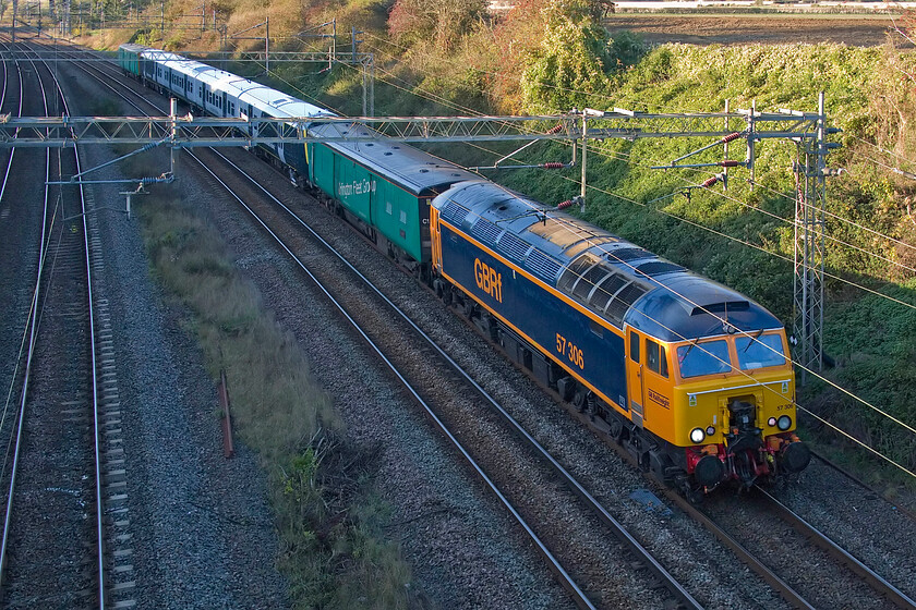 57306, 64664, 458402 & 64707, 11.40 Widnes Transport Tech-Wembley Yard (5Q63, RT), Victoria bridge 
 With the sun just too low in the mid-October afternoon to illuminate the relatively shallow cutting at Victoria bridge just south of Roade 57306 leads the 5Q63 11.40 Widness Transport Tech to Wembley Yard transfer. Immediately behind the former Thunderbird is Arlington Fleet Services translator coach 64664 'Llwet' with 64707 'Labezerin' at the rear that together form set T7. Sandwiched in the middle is a very smart-looking refurbished (but no one coach shorter) 458402. Having been at Alstom's Widness facility the Juniper set is returning to southern territory for use, not on the Portsmouth route as originally planned, but on limited outer suburban services from London Waterloo. 
 Keywords: 57306 64664 Llwet 458402 64707 Labezerin 11.40 Widnes Transport Tech-Wembley Yard 5Q63 Victoria bridge set T7