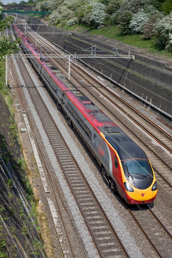 Class 390, VT 10.50 Birmingham New Street-London Euston (1B15), Roade cutting 
 Even by late-morning in the middle of May, the sun is not quite round far enough to illuminate the sides of trains passing through Roade cutting. Another Class 390 Pendolino heads south with this one working the 1B15 10.50 Birmingham to Euston Virgin service. 
 Keywords: Class 390 10.50 Birmingham New Street-London Euston 1B15 Roade cutting Virgin West Coast Pendolino