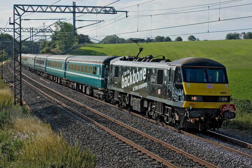 90039, 07.29 London Euston-Carlisle (1Z85, 2E), Milton crossing 
 An unadvertised private charter organised by DB Schenker was well published on the forums with considerable discussion as to what may haul the train. In the end 90039 'The Chartered Institute of Logistics and Transport' hauled the train and is seen passing Milton crossing near Blisworth that had left Euston at 07.29 heading for Carlisle running as 1Z85. Unfortunately, the lighting is not ideal at this location but any spot in this area is always going to be compromised due to its north to south configuration. 
 Keywords: 90039 07.29 London Euston-Carlisle1Z85 Milton crossing DB The Chartered Institute of Logistics and Transport"