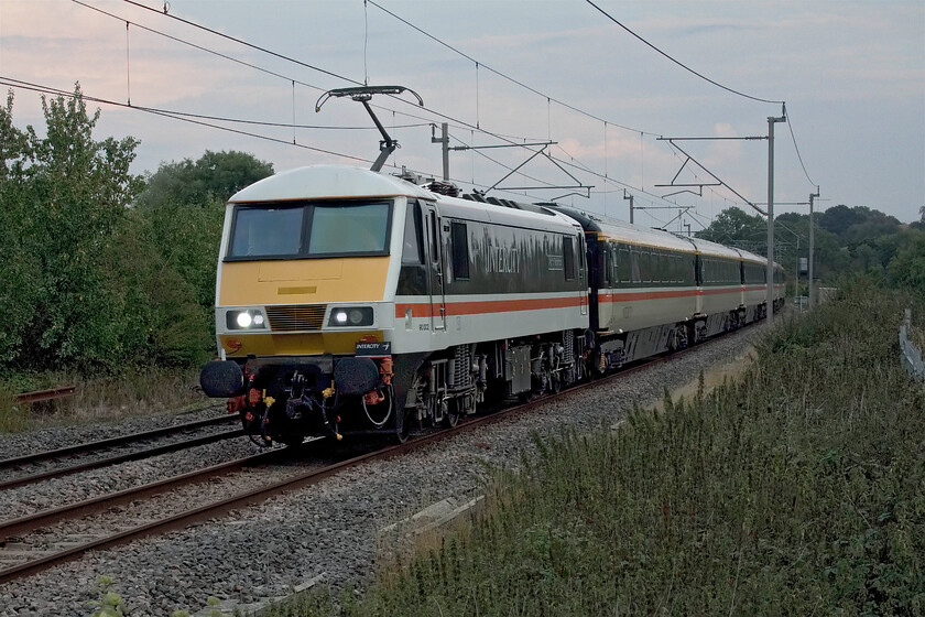 90002, LS 17.42 London Euston-Manchester Piccadilly (1Z41, 1L), Milton crossing 
 With Avanti having slashed their services on the West Coast routes, particularly those to and from Manchester Piccadilly, almost in half Crewe-based LSL saw an opportunity to operate a Friday's only return service utilising their superb rake if first-class Mk. III stock. This is their third week (of four planned) of operation and they are using 90002 'Wolf of Badenoch' to haul the train. They have operated a walk-on or advance flat fare of 75 that knocks Avanti's equivalent price into touch! In particularly poor lighting the train is seen passing Bugbrooke in Northamptonshire running bang on time as it did throughout its journey to Piccadilly via Crewe. 
 Keywords: 90002 17.42 London Euston-Manchester Piccadilly 1Z41 Milton crossing LSL Locomotive Services Limited Wolf of Badenoch