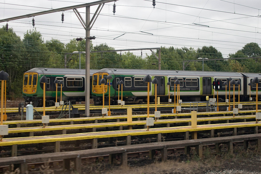 Class 319s, stabled, Bletchley Carriage Sidings 
 We came to a virtual standstill at Bletchley opposite the carriage sidings due to a freight crossing the slow lines. This gave an opportunity to photograph two of London Northwestern's retained class 319s. During the day they are stabled only seeing use at the extremely busy peak times in the early morning and evening. 
 Keywords: Class 319s stabled Bletchley Carriage Sidings