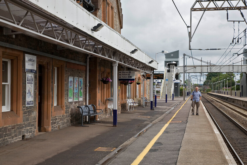 Andy, Lockerbie station 
 Despite passing through Lockerbie many times neither Andy or I have ever stopped at the station. Andy stands proudly on the down platform with the replacement fotbridge and lifts behind him that do little to match the architecture of the 1847 station building. Having said that, neither do the ugly cut-back canopies attached to the front no doubt installed during the electrification of the route in the mid 1970s. 
 Keywords: Andy Lockerbie station