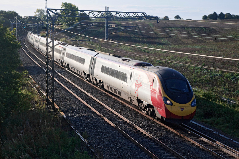 390016, VT 07.23 London Euston-Birmingham New Street (9G05, 3L), Milton Crossing 
 390106 catches the early morning sun at Milton Crossing just north of Roade Cutting as it works the 9G05 07.23 Euston to Birmingham new Street service. 
 Keywords: 390016 VT 07.23 London Euston-Birmingham New Street 9G05 Milton Crossing