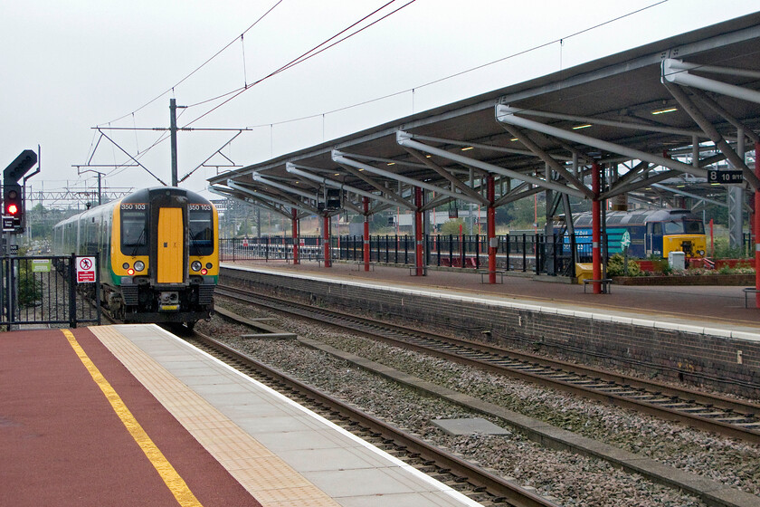 350103, LM 12.02 Crewe-London Euston (1U30) & 57308, stabled, Rugby station 
 At Rugby station 350103 departs with the 12.02 Crewe to Euston London Midland service. Meanwhile, DRS owned and operated 57308 sits in the bay platform acting as a Thunderbird ready to recover a broken down Virgin service whenever that rare event should take place. 
 Keywords: 350103 12.02 Crewe-London Euston 1U30 57308 Rugby station