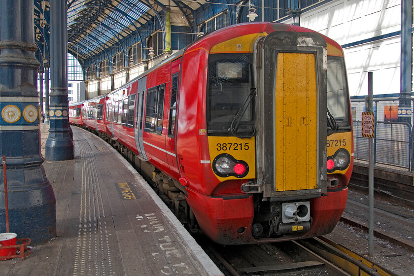 387215, GX 15.39 Brighton-London Victoria (1M87, RT), Brighton station 
 The Gatwick Express livery applied to their fleet of nineteen Electrostars is certainly pretty conspicuous! 387215 waits inside Brighton's grand trainshed to leave with the 15.39 service to Victoria. Despite driver-only operation issues prior to their introduction, these units have proved dependable on this route since their delayed introduction in 2016. 
 Keywords: 387215 15.39 Brighton-London Victoria 1M87 Brighton station Gatwick Express