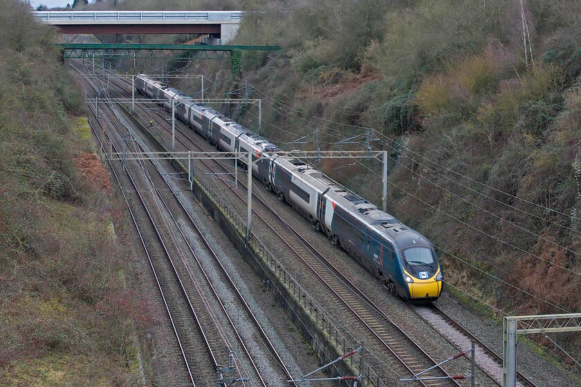 390039, VT 12.39 London Euston-Preston (9S70, 1L), Roade cutting 
 Starting my Christmas Eve walk the length of Roade cutting finds me on Bridge 210 known locally as Accomodation bridge. If I was truly going from from one end of the cutting to the other then stricktly speaking I should have started at Bridge 211 Courtenhall Road bridge but it was too far to walk! Due to it wearing Coventry's flag on the front this Pendolino is isntantly recogniseable as 390039 'Lady Godiva' seen heading north with the 12.39 Euston to Preston service. 
 Keywords: 390039 12.39 London Euston-Preston 9S70 Roade cutting