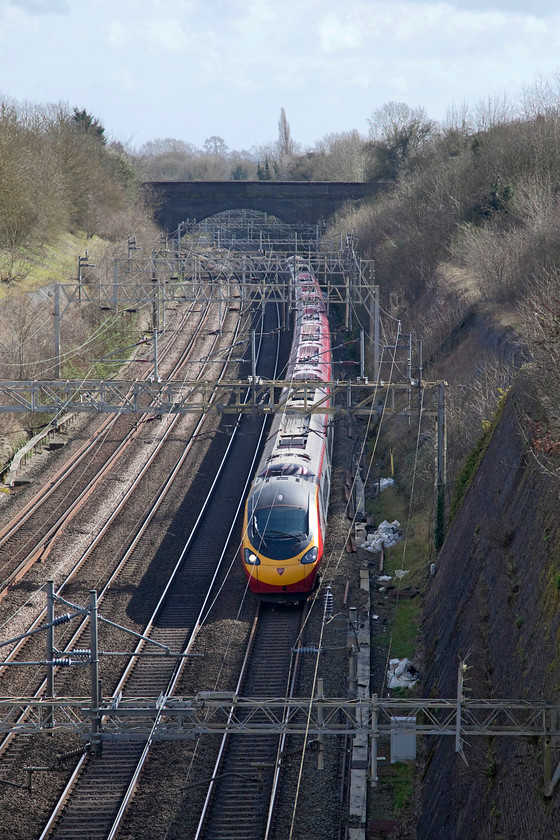 390125, VT 12.57 London Euston-Manchester Piccadilly (1H10, RT), Roade Cutting 
 390125 'Virgin Stagecoach' heads north through Roade Cutting working the 12.57 London Euston to Manchester. Taking photographs of northbound trains passing through the cutting when the sun is out is tricky anytime from ten O'clock in the morning but it is possible as the angle looks down into the cutting. I do actually like the lighting from this angle and that it breaks the photography rules! 
 Keywords: 390125 1H10 Roade Cutting